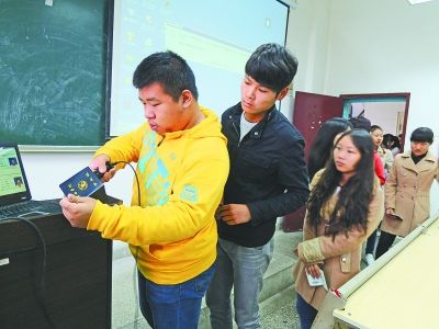 图为学生们正在扫描学生证