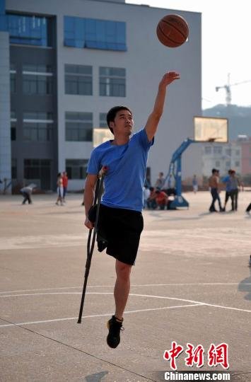 　图为拄着拐杖的瞿诗涛跳起投篮。刘占昆摄