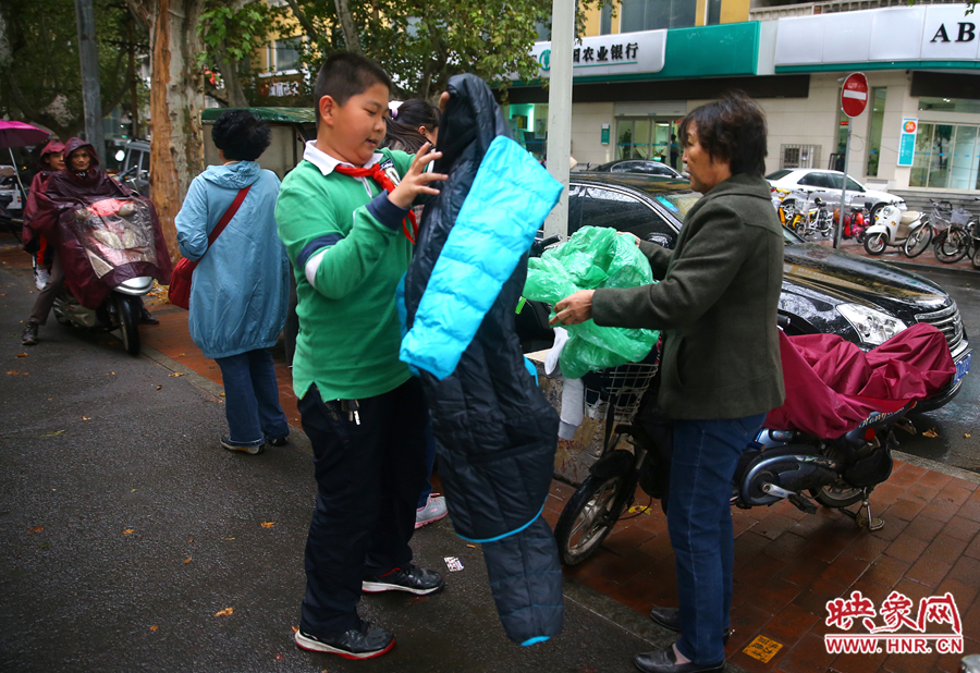 学校门口，家长给孩子带来了御寒的厚衣服。