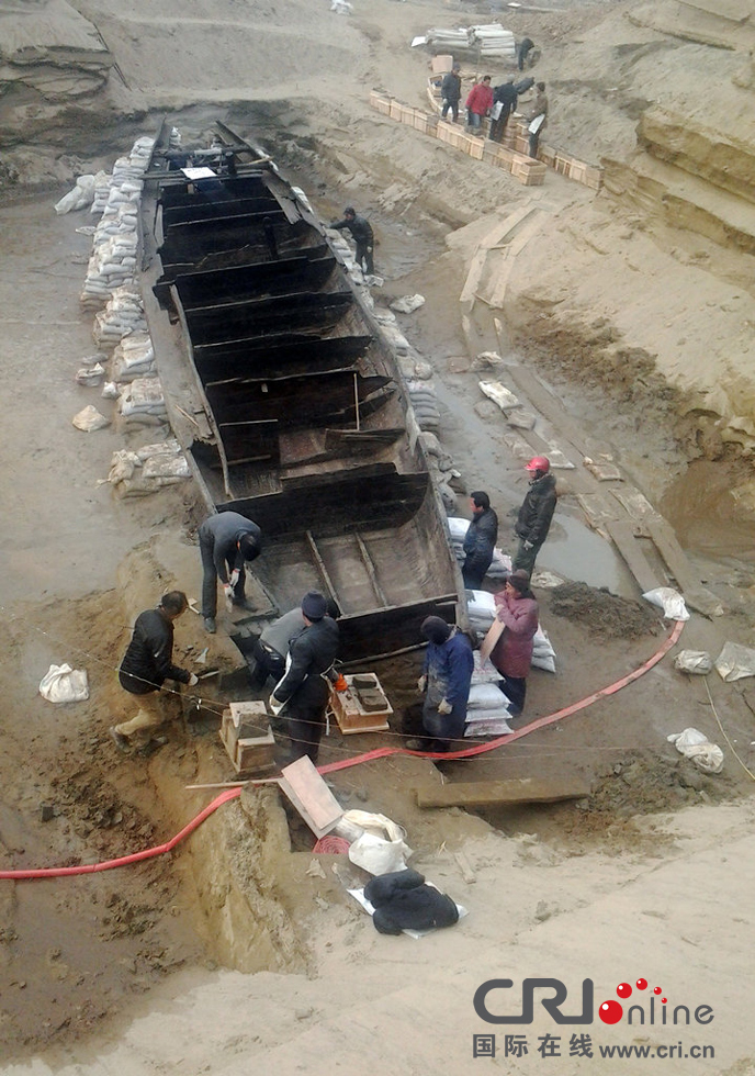 2014年1月6日，河南洛阳古沉船发掘现场，为防止古沉船受损，考古人员正在为其抹药水。