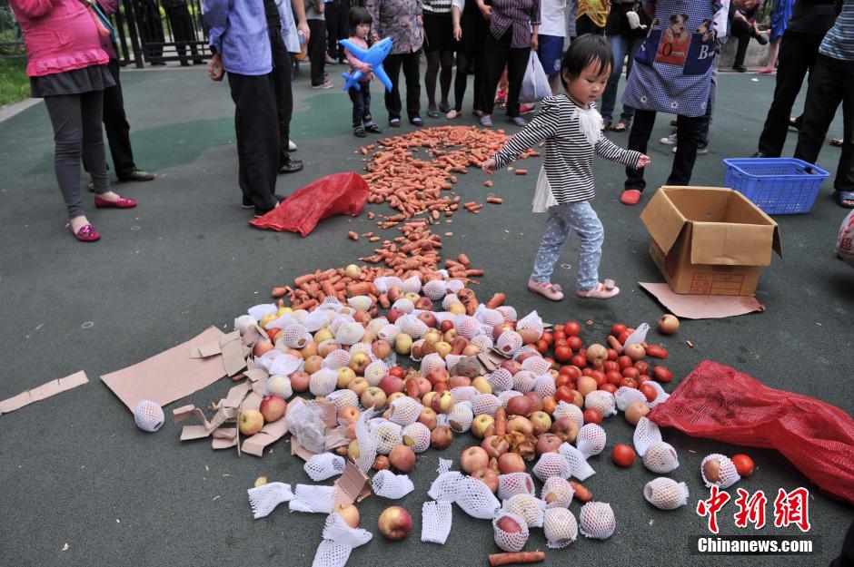 图为从幼儿园食堂里找到的发霉水果和部分蔬菜摆在幼儿园操场上。陈超 摄