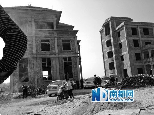 两栋被举报的违建楼下昨日一度聚集了超过百人，城管离开后逐渐散去。南都记者张志韬实习生宋超摄