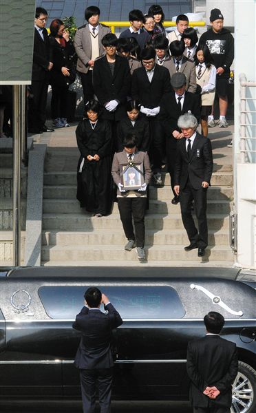 20日，韩国沉没客轮失踪乘客家属和朋友参加一名遇难高中生葬礼。