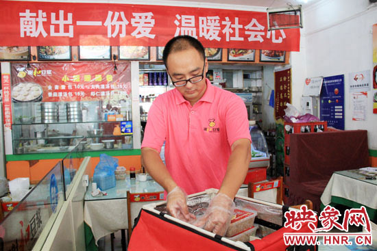 图为徐贵雨正在将一份份卤面装箱。