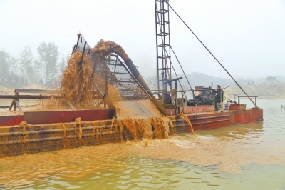 非法采沙船在板桥水库里疯狂抽沙，附近水面浑浊如泥浆。