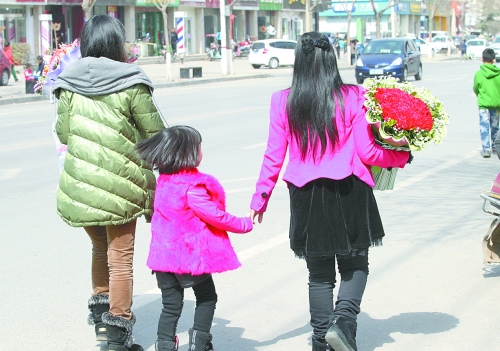 街头，两位女士手捧鲜花