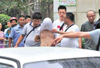 昨日，成都警方抓捕时与毒犯发生枪战。一名男犯罪嫌疑人被警方押出。