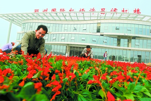 9月23日，工人们正在郑州国际机场许昌候机楼前摆放鲜花。