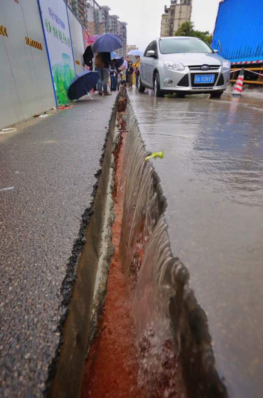 广州大道北怡新路惊现50米地裂，豪雨中两轿车被卡裂缝。 广州日报记者 苏俊杰 摄影