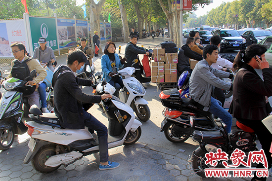 在此处等待红绿灯的电动车主请不要挡住东西走向的行人