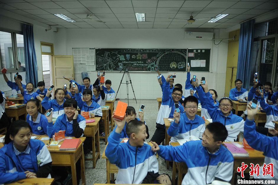 图为学生们很乐意把自己的智能手机换成非智能手机。