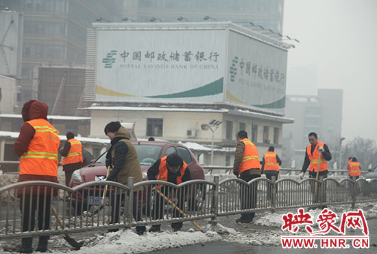 河医立交桥二层，市政工作人员及环卫工人正在清除积雪