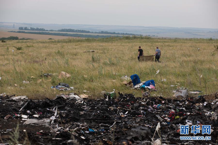 　7月19日,在乌克兰顿涅茨克州,人们在马航MH17航班坠毁现场搜寻遇难者遗体。