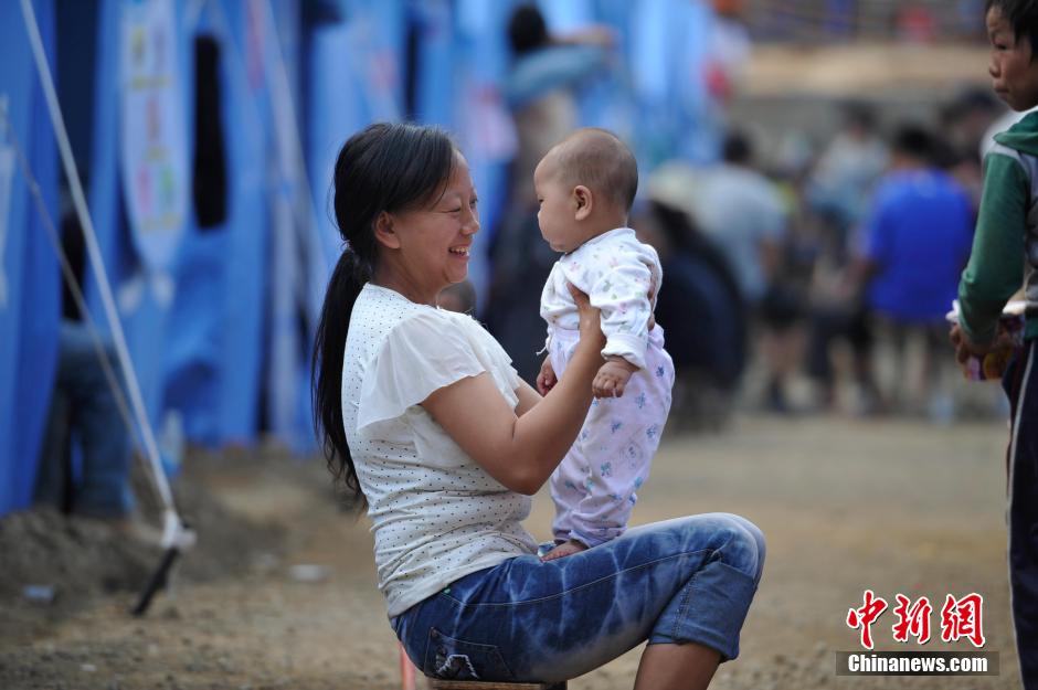 8月6日，一名年轻的母亲在和孩子玩乐。