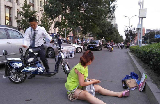 女子骑车摔倒受伤后躺在路上